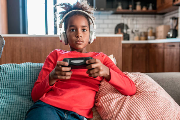istock Young girl playing video games at home 1284937361