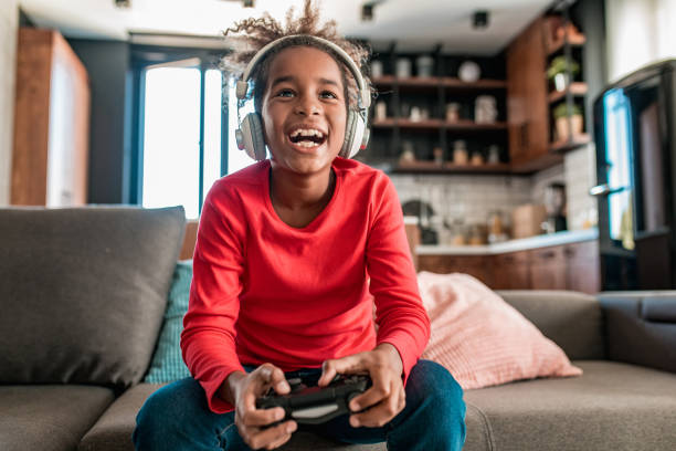 istock Young girl playing video games at home 1284937373