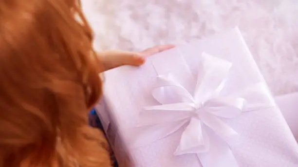 Large gift box. White color. Red hair.