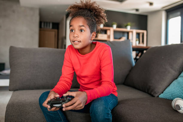 istock Young girl playing video games at home 1284937704