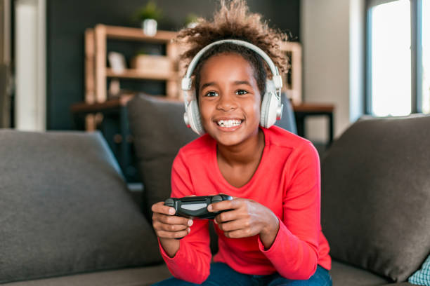 young girl playing video games at home - gaming equipment imagens e fotografias de stock