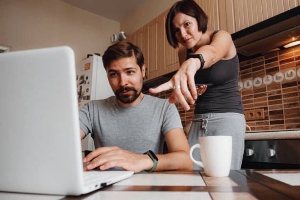 istock Couple at kitchen, reading news and using laptop. 1284938503
