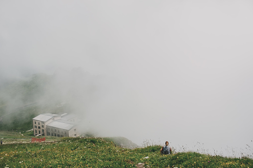 Tourist resting near the mountain station building on top of the Rochers de Naye