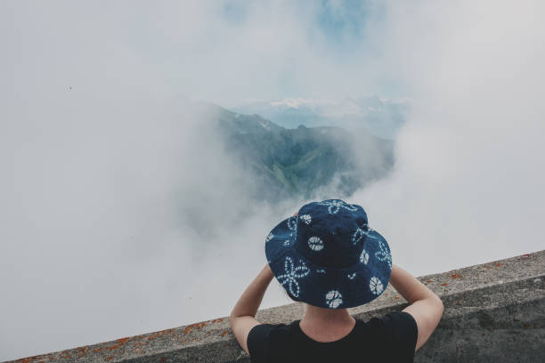 istock Tourist admires the mountain peaks in the clouds 1284939055