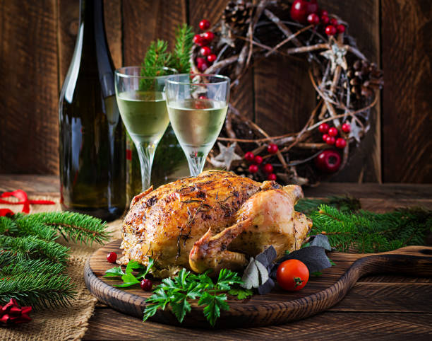 istock Baked turkey or chicken. The Christmas table is served with a turkey, decorated with bright tinsel. Fried chicken, table setting. Christmas dinner. 1284939457