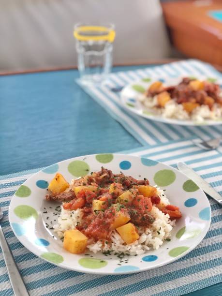 istock Dining table with two plates of rice and beef & potato stew 1284939480