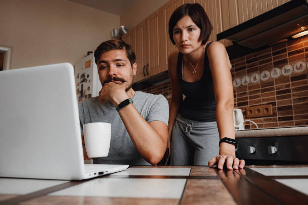 istock Couple at kitchen, reading news and using laptop. 1284940289