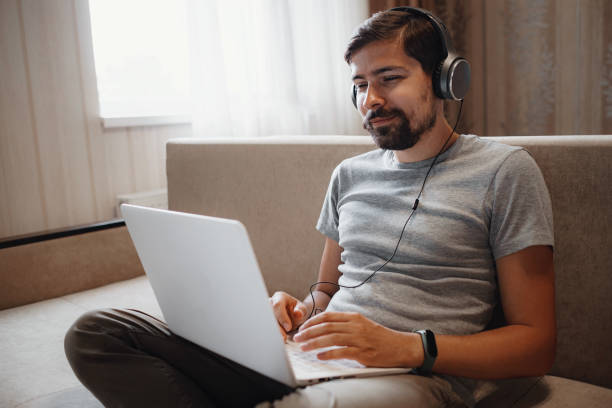 istock Remote Job. Man Working On Laptop Sitting On Sofa At Home. 1284940350