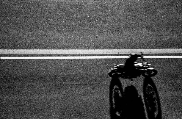アスファルト道路で彼のバイクを運転するバイカーのトップビュー - 男は彼の自転車で旅行している、上からの眺め - オートバイのラッシュ、ぼやけた動き - スピードとモーターのコンセプ� - motorcycle biker sport city ストックフォトと画像