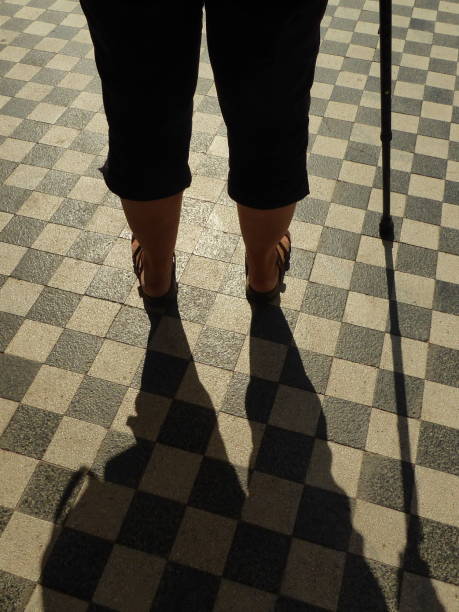 istock Old woman shadow holding cane 1284943420