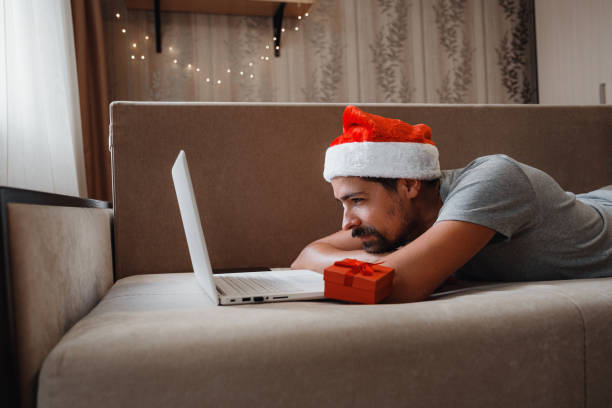 istock A hipster man with a red cup sitting at home at Christmas time. 1284943596