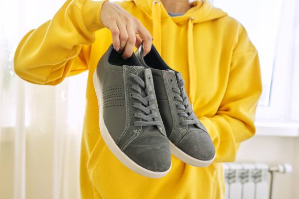 istock New men's leather gray sneakers in hands 1284951982