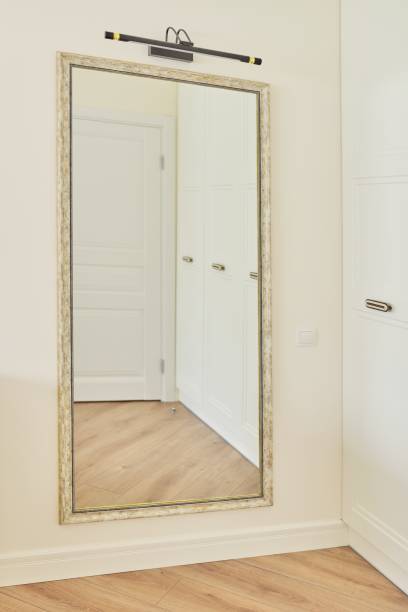 istock Large interior mirror in vintage white bronze wooden frame on wall 1284952508