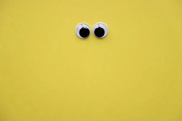 Photo of Googly eyes on yellow background