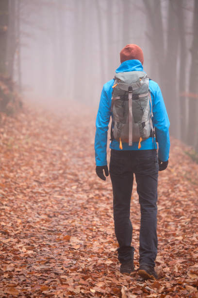 istock Man with backpack hiking alone in a forest in fall or winter 1284953740