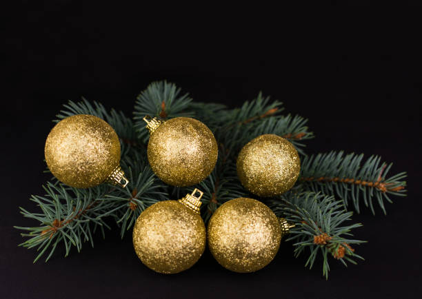 istock pine branch with golden balls on a black background. Christmas background. copy space. 1284955631