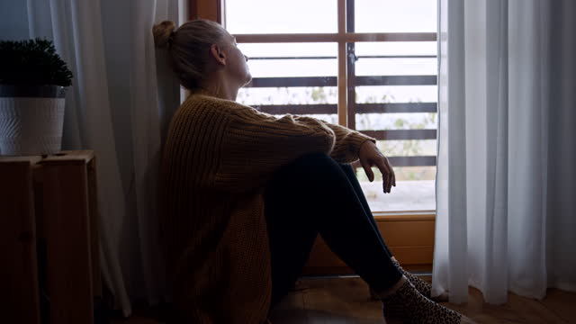 SLO MO Melancholic woman looking through a window during stay at home order