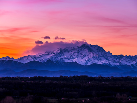 View of the Lombard Alps, the Monte Rosa chain shrouded in clouds at sunset.