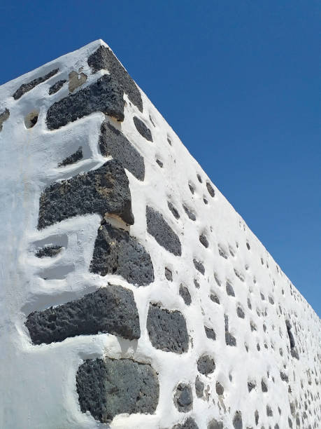 istock Typical Canarian style white wall corner. Detail of traditional architecture and construction. White rural facade and black volcanic stone. 1284958393