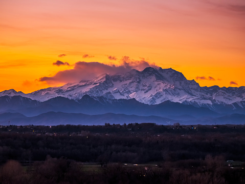 View of the Lombard Alps, the Monte Rosa chain shrouded in clouds at sunset.