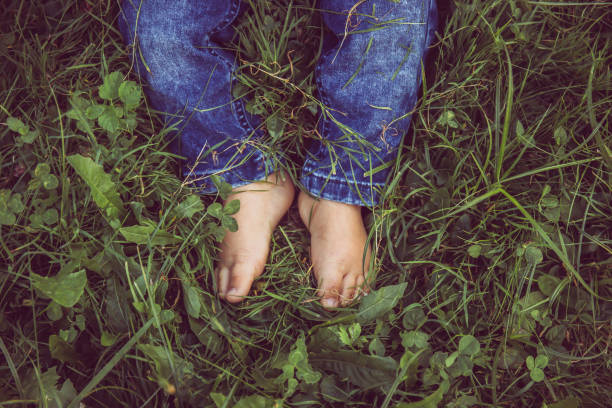 istock Small baby legs with jeans on and no socks on a grass. 1284958741