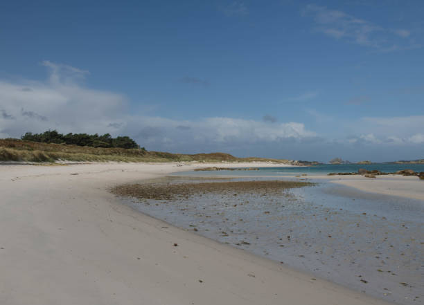 Panoramic Landscape on the Derseted Pentle Beach with a Dramatic Cloudy Blue Sky Background on the Island of Tresco in the Isles of Scilly, England, UK The Isles of Scilly are an Archipelago off the Coast of Cornwall with 5 Inhabited Islands. tresco stock pictures, royalty-free photos & images