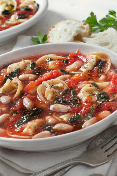 włoska biała fasola, zupa tortellini ze szpinakiem i marchewką w bulionie pomidorowym - tomato sauce tomato spinach soup zdjęcia i obrazy z banku zdjęć