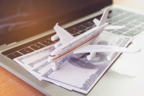 istock laptop computer and airplane and money on table. Online ticket booking concept 1284965535