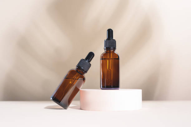 istock Glass dropper bottles on the white marble background. 1284965660