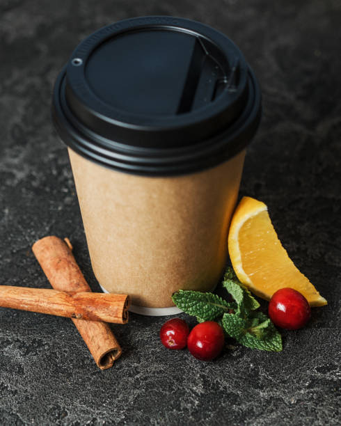 istock Christmas drinks in disposable cups. Tea with orange, cranberry and cinnamon. Dark stone background. Christmas sweets. Hot drinks in winter. New Year's menu. Seasonal winter drinks. 1284965843