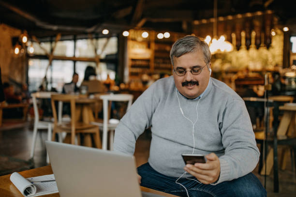 uomo adulto che lavora in una caffetteria - heavy work foto e immagini stock