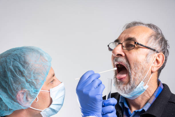 docteur dans une combinaison protectrice prenant un écouvillon nasal d’une personne pour tester l’infection possible de coronavirus. - pathogen streptococcus life science photos et images de collection