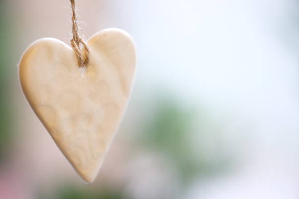 istock Shiny ceramic Christmas heart on a string on a blurred background. 1284969499