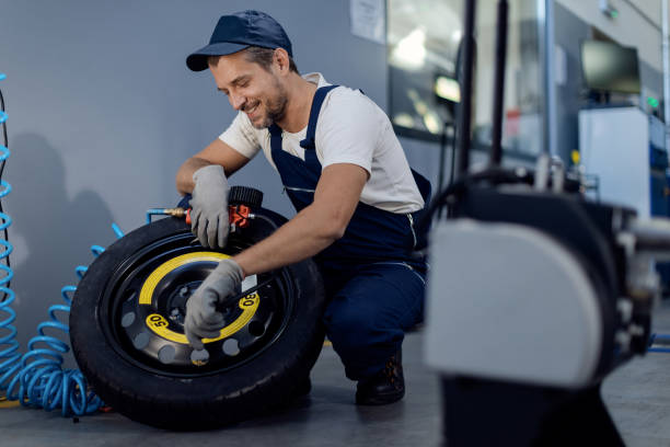 istock Happy mechanic using pressure gauge while repairing car tire in a workshop. 1284969786