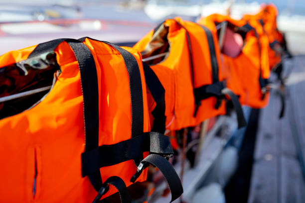 alcuni giubbotti di salvataggio arancioni luminosi sulla recinzione dello yacht - life jacket isolated red safety foto e immagini stock