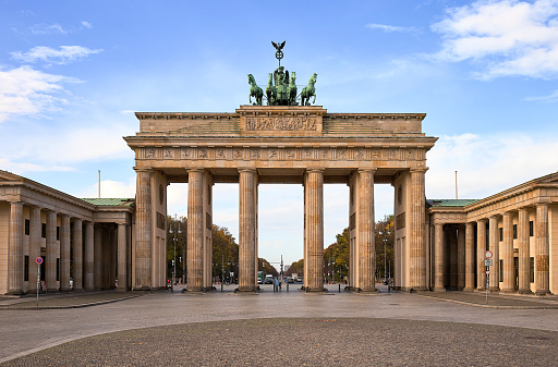 The iconic Brandenburg gate with partly cloudy deep blue sky at the edge of the Tiergarten in the heart of Berlin during the COVID-19 crisis lockdown