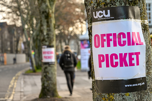Cardiff, Wales - November 2019: Sign attached to a tree near an official picket line outside Cardiff University. It marks industrial action by members of the Universities and College Union.