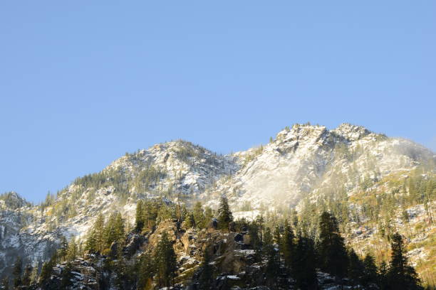 istock Tall Mountain With Snow Against Soft Blue Sky 1284981016