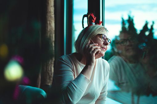 Senior woman celebrating christmas on the phone