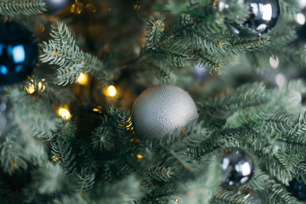 istock New Year 2020. Christmas beautiful lights on dark cold background. Defocused lights on a tree background. Gray Christmas toy. abstract, blinking, blurred, soft focus, out of focus, blur. 1284984518