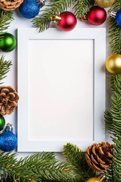 istock Christmas composition with empty picture frame. Colorful ball ornament, pine cones and fir needles decorations. Mock up greetings card template 1284986539