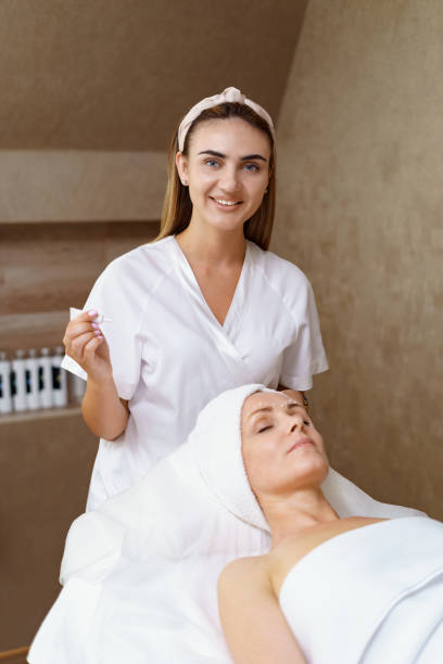 istock Cosmetologist applying cream on face 1284987334