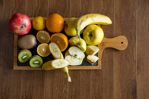 Close up of fresh fruits on cutting board on wooden table