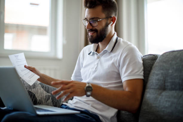 istock Smiling young man with wireless headphones using laptop for video call from home 1284991887