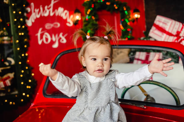 istock baby sitting on red Christmas car 1284996620