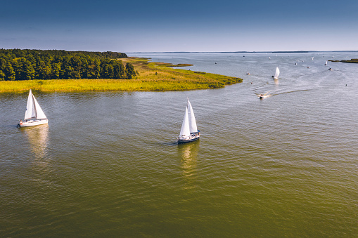 Aerial view of yachts on the Przeczka Strait, which connects Mikołajskie Lake with the Śniardwy Lake in the Masurian Lake District. Masuria is a region in north-eastern Poland famous for its 2,000 lakes.