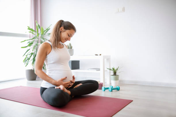 donna incinta che esercita a casa. - human pregnancy exercising relaxation exercise sport foto e immagini stock