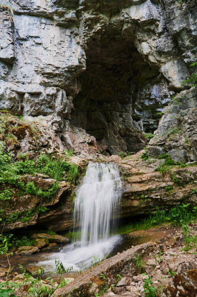 istock view of a small mountain river waterfall among large cobblestones from a cliff. 1284999499