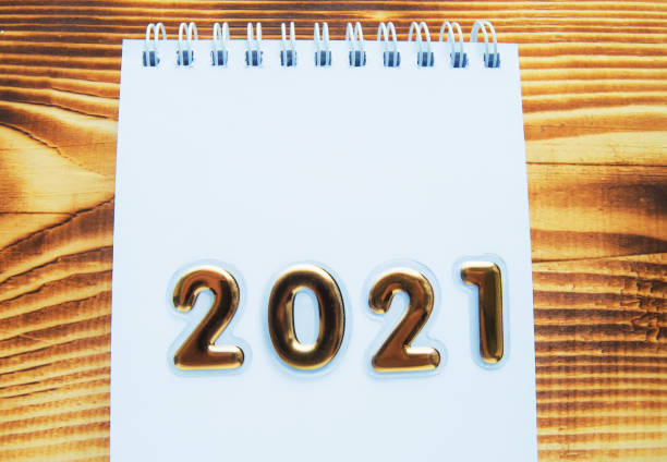 istock Happy New year layout, numbers with Golden numbers 2021 Notepad and free space for text, background-wooden Board 1284999714