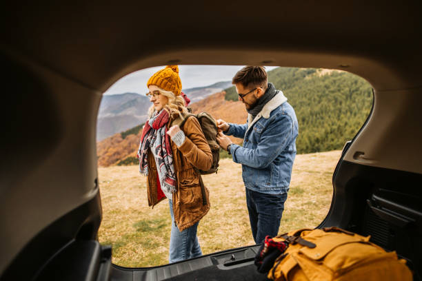 istock Group of hikers getting backpacks from car trunk, ready for hiking 1285000650